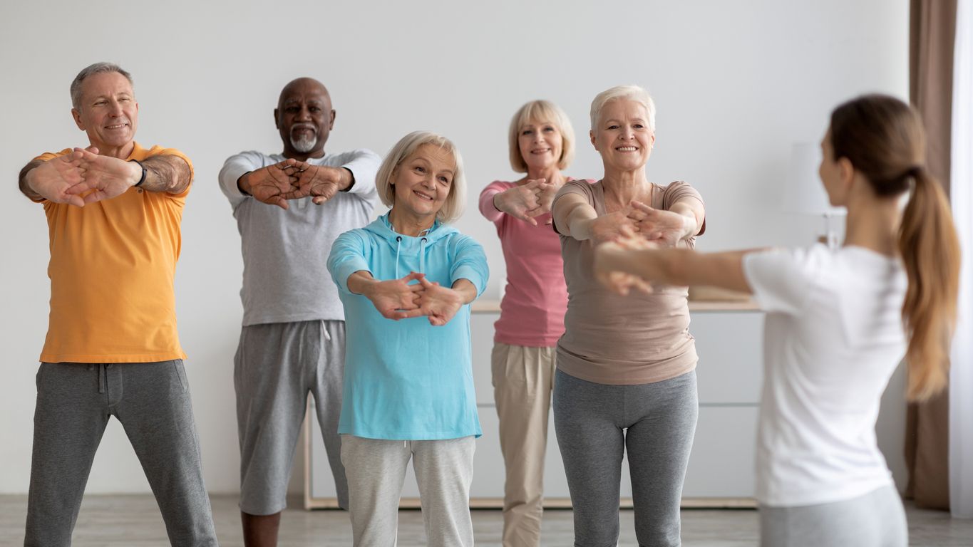A class of seniors practices their balance together