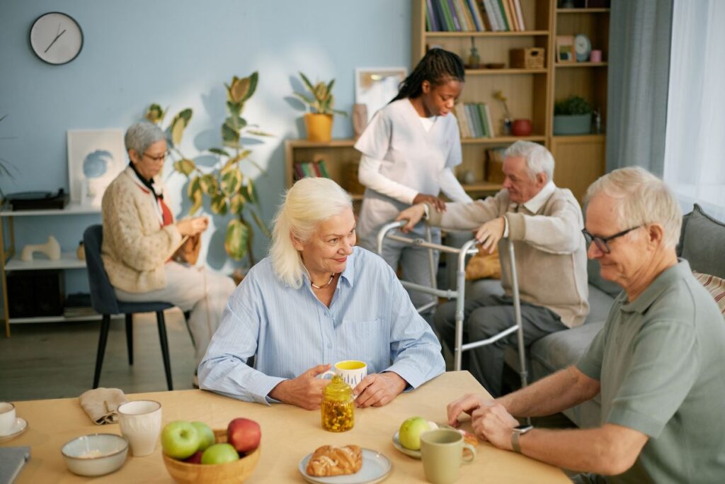 Seniors enjoy a light meal and conversation in an assisted living environment.