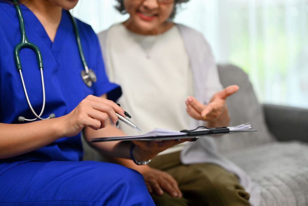 An in-home nurse helps a woman go through paperwork.